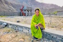 Parveen Bibi in Darkut Colony in front of a water tank that is filled by a solar-powered pump.